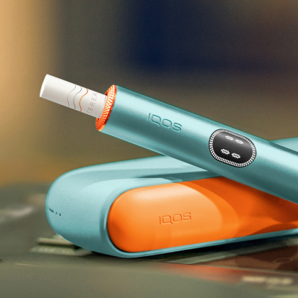 Breeze Blue IQOS ILUMA i device above its charger, with customed door and rings